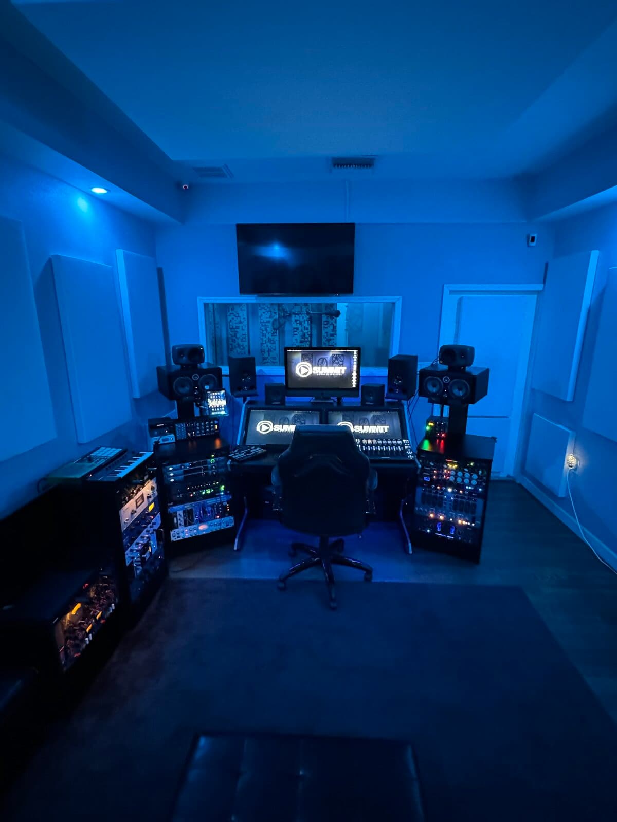 The control room seen from the doorway: outboard racks, the desk and the live room window